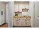 Wet bar featuring beige cabinets with black hardware, light marble countertop, and stainless steel sink at 111 Carter Ln, Canton, GA 30115
