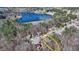 Aerial view of a home with a well-manicured lawn and mature trees near a lake at 1915 Turtle Creek Way, Lawrenceville, GA 30043