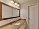 Bathroom featuring a granite countertop, large framed mirror, and modern lighting fixture at 1915 Turtle Creek Way, Lawrenceville, GA 30043