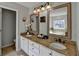 Bathroom with dual sinks, granite counters, framed mirrors, and white cabinets at 1915 Turtle Creek Way, Lawrenceville, GA 30043