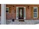 Elegant front door with sidelights and decorative glass, framed by brick and sconce lighting at 1915 Turtle Creek Way, Lawrenceville, GA 30043