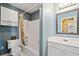 Well-lit bathroom with a tub and shower, white vanity, and built-in shelving for convenient storage at 918 Fox Hollow Way, Marietta, GA 30068