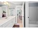 Bright bathroom featuring a white vanity, framed mirror, and an open doorway to the primary bedroom at 918 Fox Hollow Way, Marietta, GA 30068