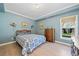 Stylish blue bedroom with vintage furniture, hardwood floors, bright window, and unique wall sconces at 918 Fox Hollow Way, Marietta, GA 30068