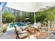 Covered patio area featuring comfortable seating overlooking the in-ground pool at 160 Peachtree Ne Way, Atlanta, GA 30305