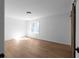 Bright bedroom with light wood floor, white walls and ceiling, window, and barn door at 513 S Malton Ct, Stone Mountain, GA 30083