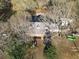 Aerial view of a home featuring a symmetrical roofline and ample parking surrounded by mature trees at 75 Price Dr, Locust Grove, GA 30248
