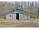 Exterior shot of a grey barn with a sliding door, showing its sturdy construction and design at 75 Price Dr, Locust Grove, GA 30248