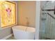 Bathroom featuring a stained glass window, a stand alone tub, and a glass enclosed shower at 75 Price Dr, Locust Grove, GA 30248