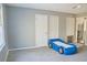 Bright bedroom with neutral walls, carpeted floor and a blue car shaped bed at 75 Price Dr, Locust Grove, GA 30248