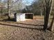 Exterior view of wooden livestock shelter surrounded by open land and bare trees at 75 Price Dr, Locust Grove, GA 30248