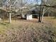 Exterior view of wooden livestock shelter surrounded by open land and bare trees at 75 Price Dr, Locust Grove, GA 30248