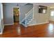 Living room with hardwood flooring, white stairs, and kitchen view at 75 Price Dr, Locust Grove, GA 30248