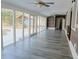 Sunroom with a pool view, gazebo, vinyl floors, wood-style paneling, and multiple ceiling fans at 75 Price Dr, Locust Grove, GA 30248