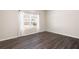 A bright bedroom with light-colored walls, wood-look flooring and a window with bright white curtains at 146 Point View Dr, Canton, GA 30114