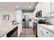 Modern kitchen boasts white cabinets, granite countertops, and stainless steel appliances for a sleek look at 146 Point View Dr, Canton, GA 30114