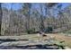 Large backyard with a stone patio, fire pit, trampoline, and lots of trees, a great space for recreation at 2030 Habersham Trce, Cumming, GA 30041