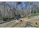A landscaped backyard with a fire pit, trampoline, and a stone retaining wall, creating a tranquil outdoor retreat at 2030 Habersham Trce, Cumming, GA 30041