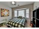 Cheerful bedroom featuring a bay window, green plaid bedding, and artwork at 2030 Habersham Trce, Cumming, GA 30041