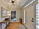 Bright foyer featuring hardwood floors, stylish lighting, and a glimpse into the dining area at 2030 Habersham Trce, Cumming, GA 30041