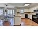 Kitchen with white cabinets, black appliances, breakfast bar, and hardwood floors at 2030 Habersham Trce, Cumming, GA 30041
