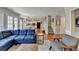 Spacious living room with hardwood floors, fireplace, blue sectional sofa, and views into other rooms at 2030 Habersham Trce, Cumming, GA 30041