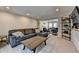 Comfortable living room features a large gray sectional sofa, entertainment center, and views into other rooms at 2030 Habersham Trce, Cumming, GA 30041