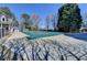 Large in-ground pool is covered and set in a concrete patio surrounded by trees and foliage at 2030 Habersham Trce, Cumming, GA 30041
