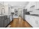 Well-lit kitchen featuring stainless steel appliances, white cabinets, and a herringbone tile backsplash, creating a modern aesthetic at 6037 Queens River Dr, Mableton, GA 30126