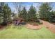 Landscaped backyard with lush lawn, wooden fence, and playground; ideal for outdoor activities at 1211 Thornwell Ne Dr, Brookhaven, GA 30319