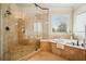 Bright bathroom with glass shower and soaking tub with tile surround at 1211 Thornwell Ne Dr, Brookhaven, GA 30319