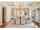 Elegant dining room with a coffered ceiling, chandelier, and a large table set for a formal gathering at 1211 Thornwell Ne Dr, Brookhaven, GA 30319