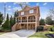 Beautiful two-story home with a covered porch and two-car garage, accented by stone detailing and lush landscaping at 1211 Thornwell Ne Dr, Brookhaven, GA 30319