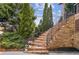 Elegant stone staircase leading to the front entrance, framed by mature trees and decorative landscaping at 1211 Thornwell Ne Dr, Brookhaven, GA 30319