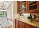 Butler's pantry with granite counters and glass-front cabinets in between kitchen and dining room at 1211 Thornwell Ne Dr, Brookhaven, GA 30319