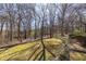 A lush backyard with a grassy lawn and a treed area in the background at 133 Hickory Trl, Cumming, GA 30040