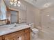 A bathroom featuring a single sink, vanity, toilet, and a shower-tub with white tiling at 133 Hickory Trl, Cumming, GA 30040