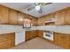 Traditional kitchen with wood cabinets, white appliances, tile flooring, and a ceiling fan with light at 133 Hickory Trl, Cumming, GA 30040