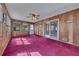 Inviting sun room featuring wood paneling, red carpet, multiple windows, and sliding glass doors at 133 Hickory Trl, Cumming, GA 30040