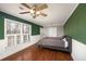 This bedroom features a ceiling fan, white-wood blinds, and a gray and green accent wall at 2870 Carla Nw Dr, Kennesaw, GA 30144