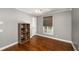 A simple bedroom space with a ceiling fan, a shelf for storage, and a gray accent wall at 2870 Carla Nw Dr, Kennesaw, GA 30144