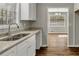 Kitchen area with a double sink, granite countertops, white cabinets, and wood-look flooring at 2911 Botany Dr, Jonesboro, GA 30236