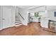 Open-concept living room and kitchen features hardwood floors, stairs, and a modern island with seating at 1893 Burning Tree Dr, Decatur, GA 30032