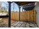 Cozy back patio area shows a stone tile floor, a wooden fence, and support posts for an upper deck at 380 Grant Se Cir # 306, Atlanta, GA 30315