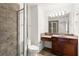 Neutral tiled bathroom featuring glass shower, toilet and vanity with a dark wood cabinet and light countertop at 380 Grant Se Cir # 306, Atlanta, GA 30315