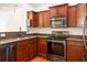 Well-equipped kitchen featuring stainless steel appliances, wood cabinets, and sleek granite countertops at 380 Grant Se Cir # 306, Atlanta, GA 30315