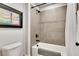 Tiled bathtub with shower featuring modern fixtures, neutral tones, and artistic decor at 4732 Cooling Water Cir, Powder Springs, GA 30127