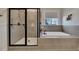 Bathroom with a glass shower, a soaking tub, and gray tiled walls at 4732 Cooling Water Cir, Powder Springs, GA 30127
