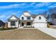 Beautiful two-story home featuring a light brick facade, covered entryway, and two-car garage, complemented by professional landscaping at 4732 Cooling Water Cir, Powder Springs, GA 30127