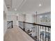 Upstairs hallway featuring carpet flooring, dark metal railings, and natural light streaming through a window at 4732 Cooling Water Cir, Powder Springs, GA 30127